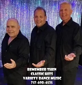 Three men standing in front of a blue background.